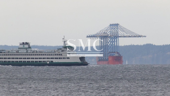 Massive container cranes, welded to a ship, will cruise through Puget Sound Friday: here’s how to watch